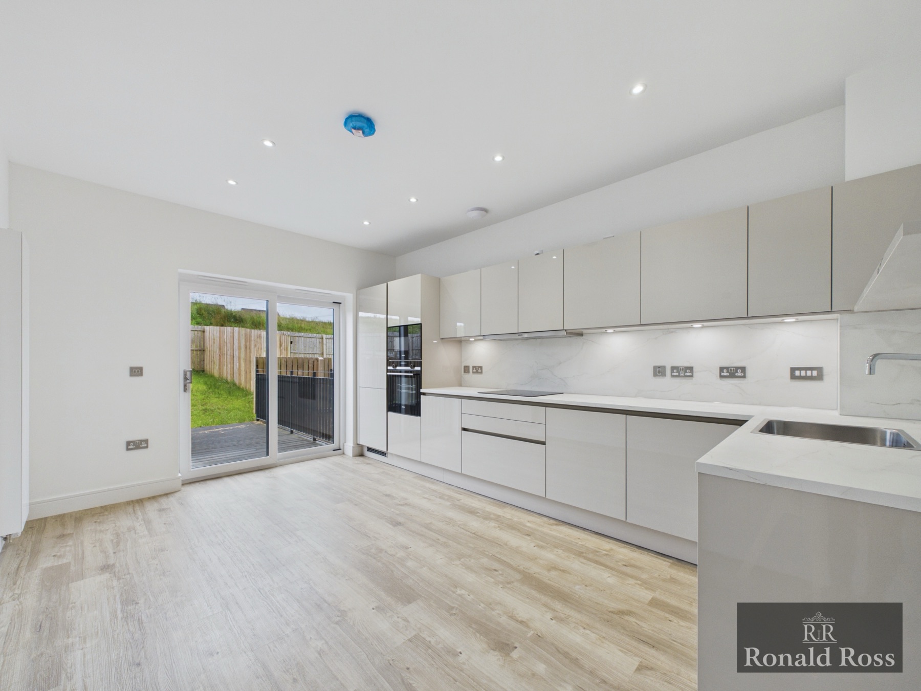 A newly finished white kitchen and dining space from a Ronald Ross listing